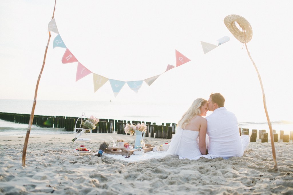 Photo romantic scene at the beach picnic, bride and groom look into the sunset